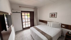 A hotel room with a bed, a TV, a window, and a door. - Rede Andrade Estrela Dalva Praia (Porto Seguro)