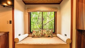 A room with a wooden bed, a window with a view of trees, and a wooden ceiling. - Secret Bungalows Lechu (Penas Blancas)