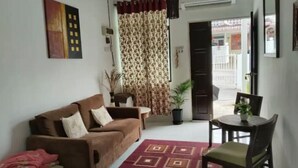 A living room with a sofa, a dining table with chairs, a patterned rug, and a potted plant. - 
TSA Yasmin House, Kuah, Langkawi, Kedah Malaysia (Langkawi)