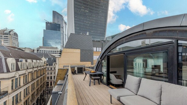 A rooftop terrace with a wooden deck, a sofa, and a table. - Your Apartment - Tower of London (London)