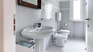 A modern bathroom with a large sink, two toilets, and a mirror. - Three-room flat Apartment Scola 21 (Gabicce Mare)