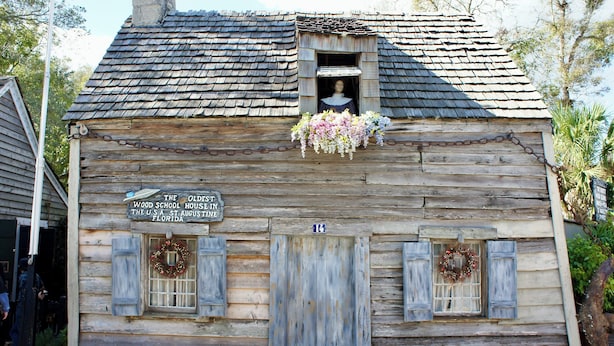 A rustic wooden building with a sign indicating it is a historic schoolhouse.