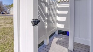 A white wooden pergola with a lattice design and a metal gate. - Spacious 4-bedroom Single home in Ocean View with large outdoor spaces and Pool! (Ocean View)