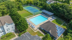 Zona residencial con piscina, canchas de tenis y paneles solares.