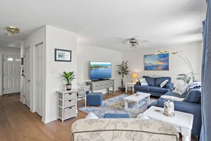 A living room with a television, sofa, and coffee table.