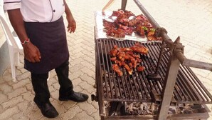 Une personne qui fait griller de la viande à l’extérieur.