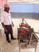 Alguém grelhando carne ao ar livre.