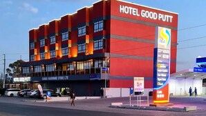Un immeuble à plusieurs étages, sur lequel on peut voir une enseigne bien visible indiquant « HÔTEL GOOD PUTT ».