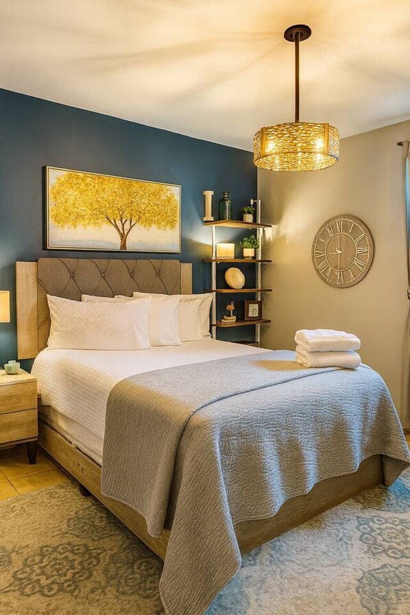 Une chambre à coucher comprenant un lit, une table de chevet, une commode, une horloge murale, une étagère avec des objets décoratifs et un luminaire suspendu.