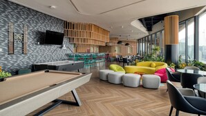 Een moderne lounge met een pooltafel, zitplaatsen en een bar.