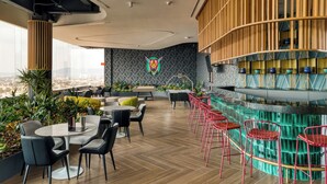Een moderne lounge met een pooltafel, barstoelen en uitzicht over de stad.