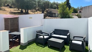 An outdoor patio with a sofa set, a table, and chairs. - CERRO LUNA HOUSE (Constantina)