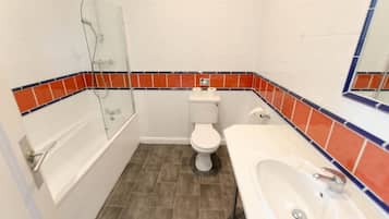 Un baño con bañera, inodoro y lavamanos.