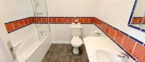 A bathroom with a bathtub, toilet, and sink.