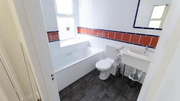 Un baño con bañera, inodoro y lavabo.