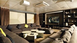 A modern living room with a sectional sofa, two round coffee tables, a flat-screen TV, and a fireplace. - Student Only Vita First Street (Manchester)