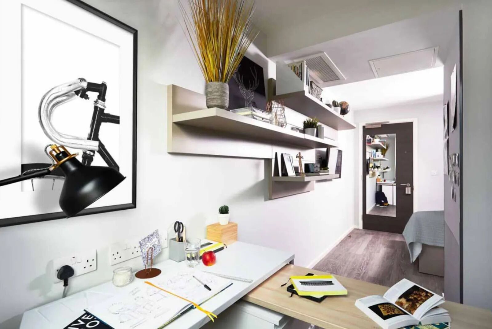 Un moderno spazio ufficio con una scrivania, mensole e un quadro con una lampada.