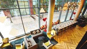 A spacious indoor area with a large window, a checkered table, and several seating arrangements. - Student Only Vita First Street (Manchester)
