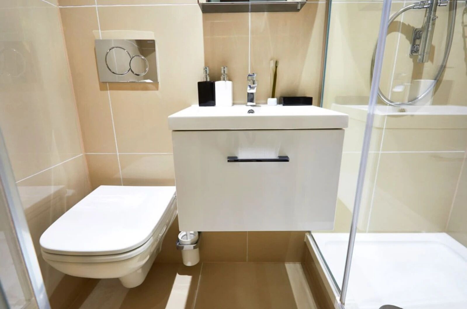 Une salle de bain comprenant des toilettes, un lavabo avec un miroir et un espace douche.