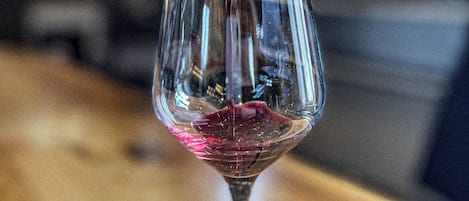Rotwein wird in ein Weinglas gegossen.