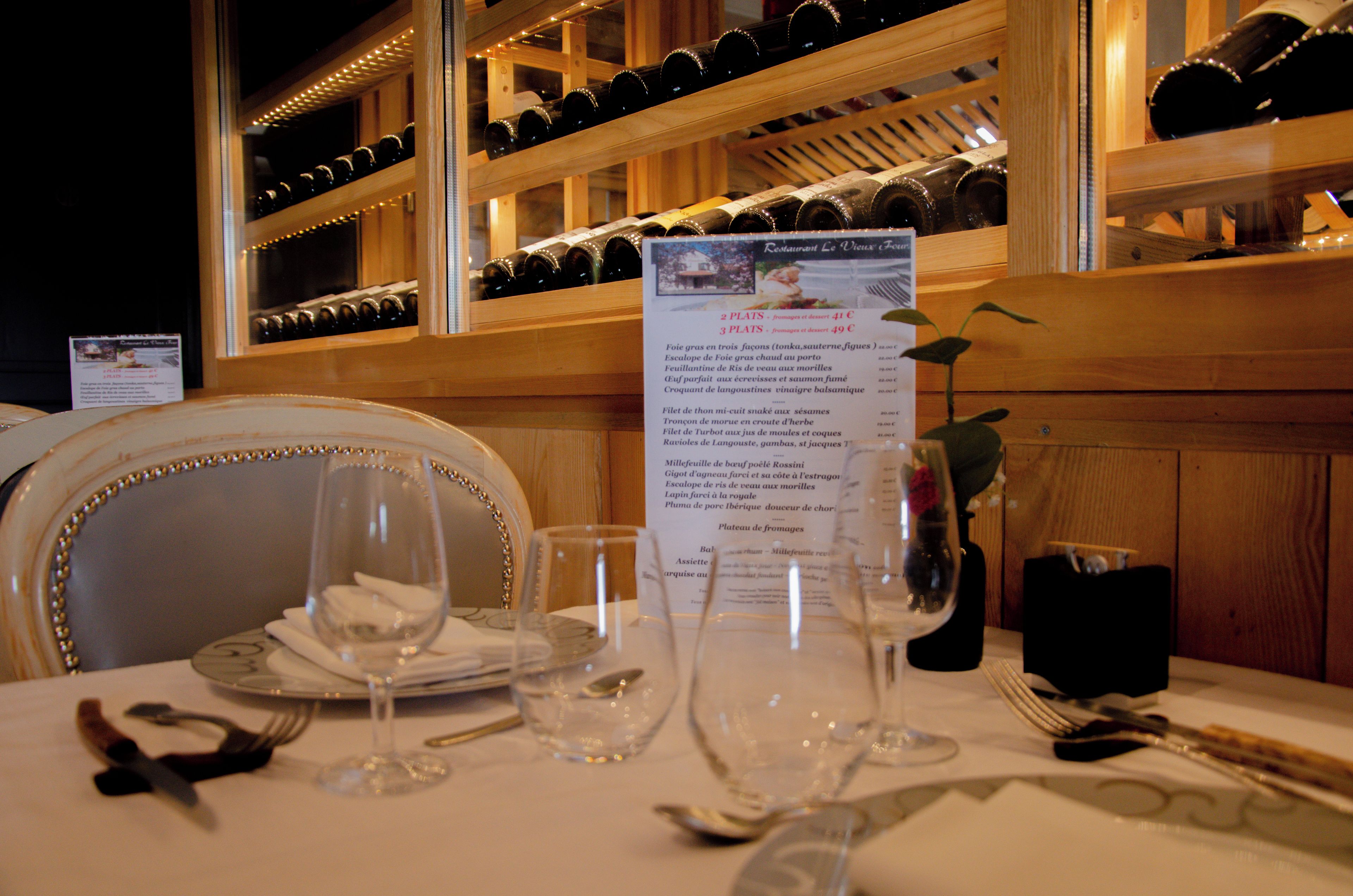 A table set for dining with wine glasses, cutlery, and a menu.