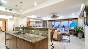 Una cocina amplia con encimeras de granito, una isla de madera y un comedor con vistas.