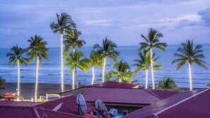 Terraza de hotel con antenas parabólicas, palmeras y vistas al océano.