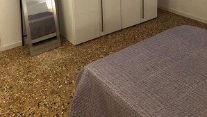 Un dormitorio con cama, armario y espejo.