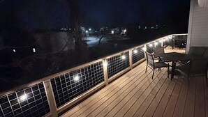 A wooden deck with a railing, a table, and chairs. - Bed N Bikefast - Side B (Bentonville)
