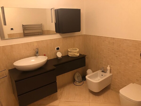 A modern bathroom with a large white sink, a black vanity, a bidet, and a toilet. - Rio Carmini (Venice)
