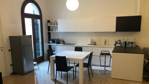 A compact kitchen with a dining area, a refrigerator, a microwave, and a sink. - Rio Carmini (Venice)