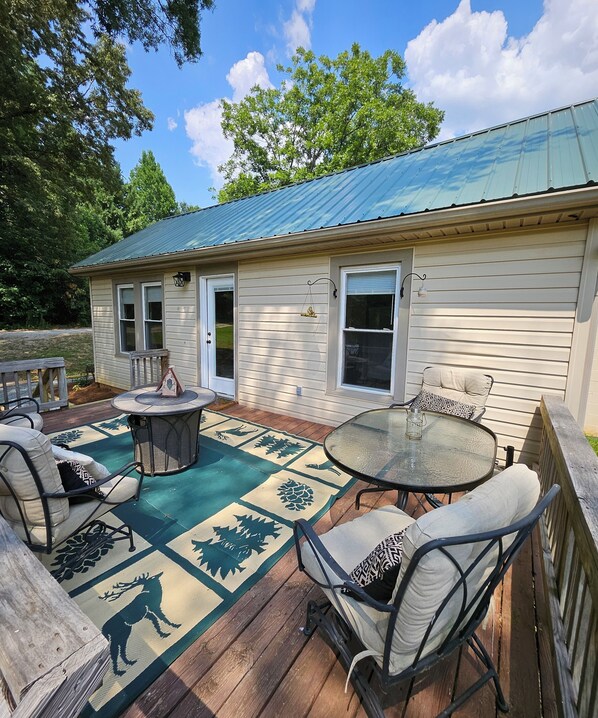 A house with a covered patio, outdoor seating, and a decorative rug.