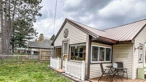 Een gelijkvloers huis met een voortuin, een vuurkorf en een omheinde tuin.