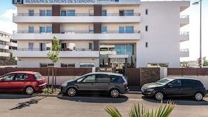 Edifício de idosos com vários andares, com placa indicando ser uma residência para idosos.