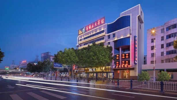 Un hôtel à plusieurs étages, reconnaissable à son grand panneau rouge placé sur le dernier étage.
