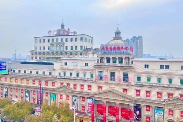 A historic building with classical architecture, including a dome and columns, and a modern building with a flat roof in the background. - Forever Star Hotel (Fuyang)