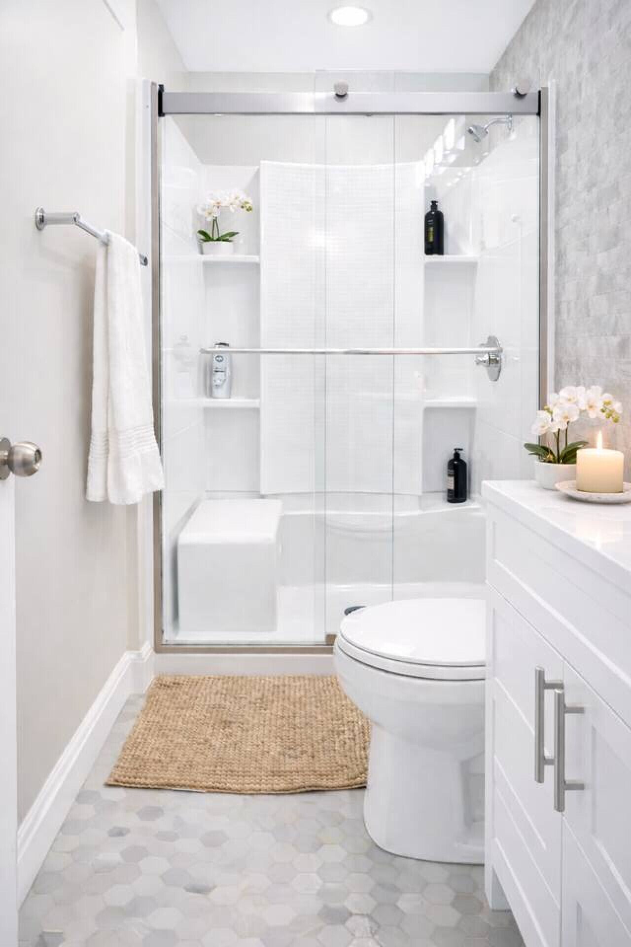 A modern bathroom with a glass shower enclosure, a toilet, and a vanity with a mirror.