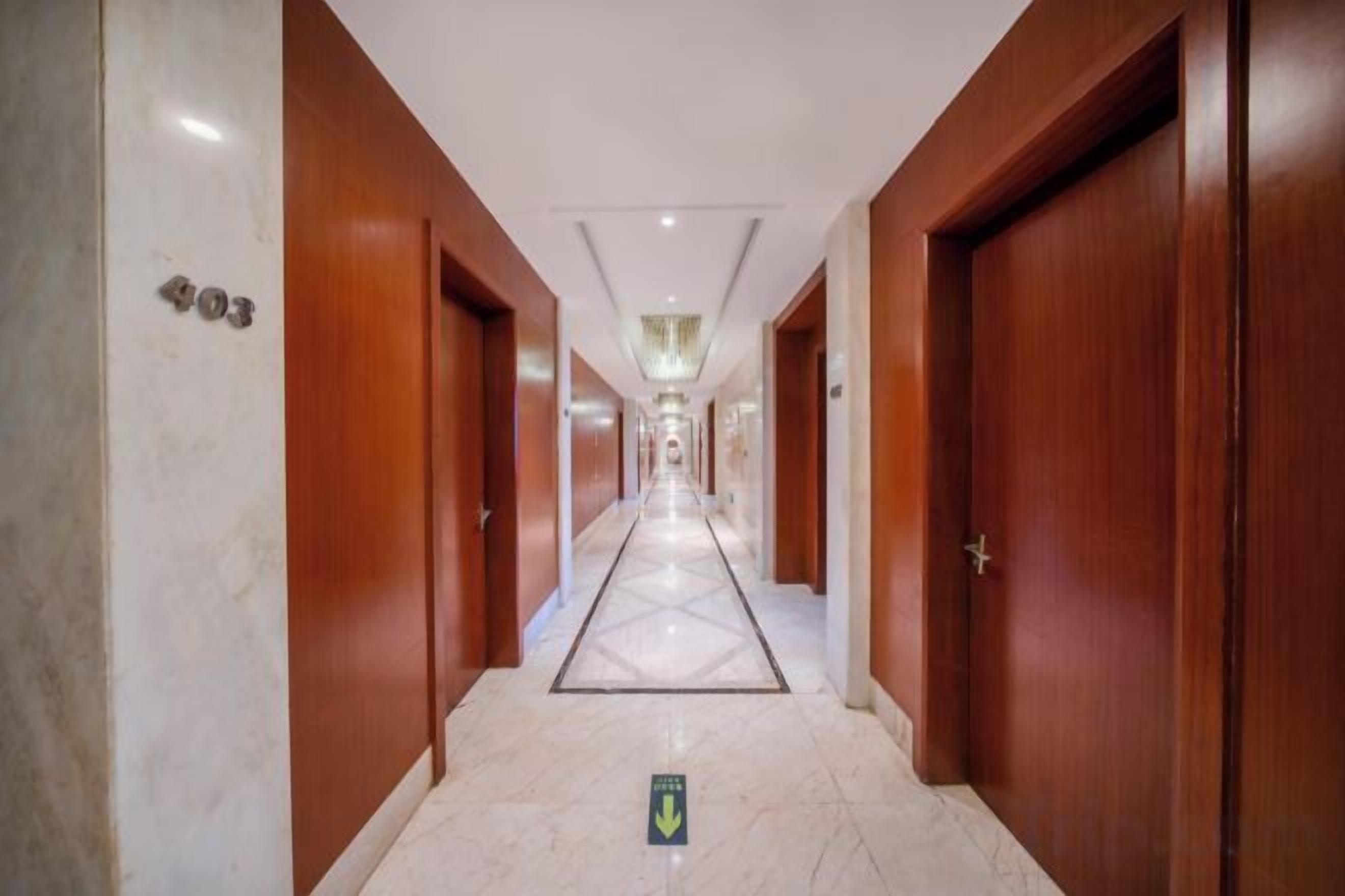 Ein Hotelgang mit Holztüren, darunter die Nummer 403, und einem Marmorboden.