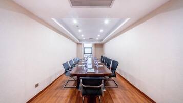 A conference room with a long table, chairs, and a ceiling vent.