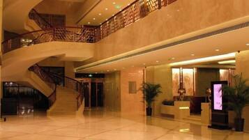 A spacious lobby with a grand staircase, polished floors, and modern decor.