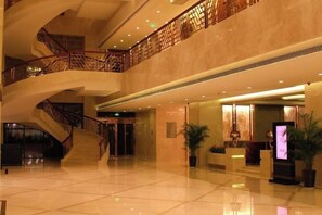 A spacious lobby with a grand staircase, polished floors, and modern decor. - Shimao Hotel (Zhoushan)