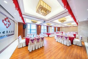 A banquet hall with round tables, white chairs, and red accents. - Shimao Hotel (Zhoushan)