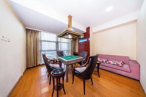 A room with a pool table, chairs, a sofa, and a window with curtains. - Shimao Hotel (Zhoushan)