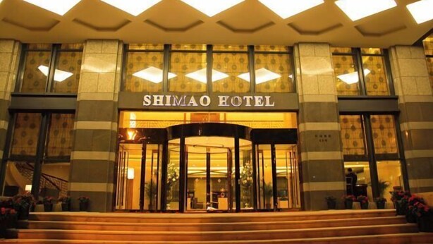 Der Eingang des Shimao Hotels mit einer zentralen Drehtür und einer gefliesten Fassade.
