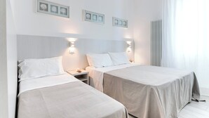 A hotel room with two beds, a nightstand, wall-mounted lights, and framed pictures on the wall. - Four-room apartment Scola 01 (Gabicce Mare)