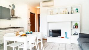 A modern kitchen with white cabinetry, a built-in stove, and a stainless steel range hood.