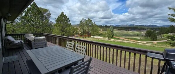 A deck with a table and chairs, overlooking a golf course and mountains. - New Listing! Granite Heights in Custer State Park (Custer)