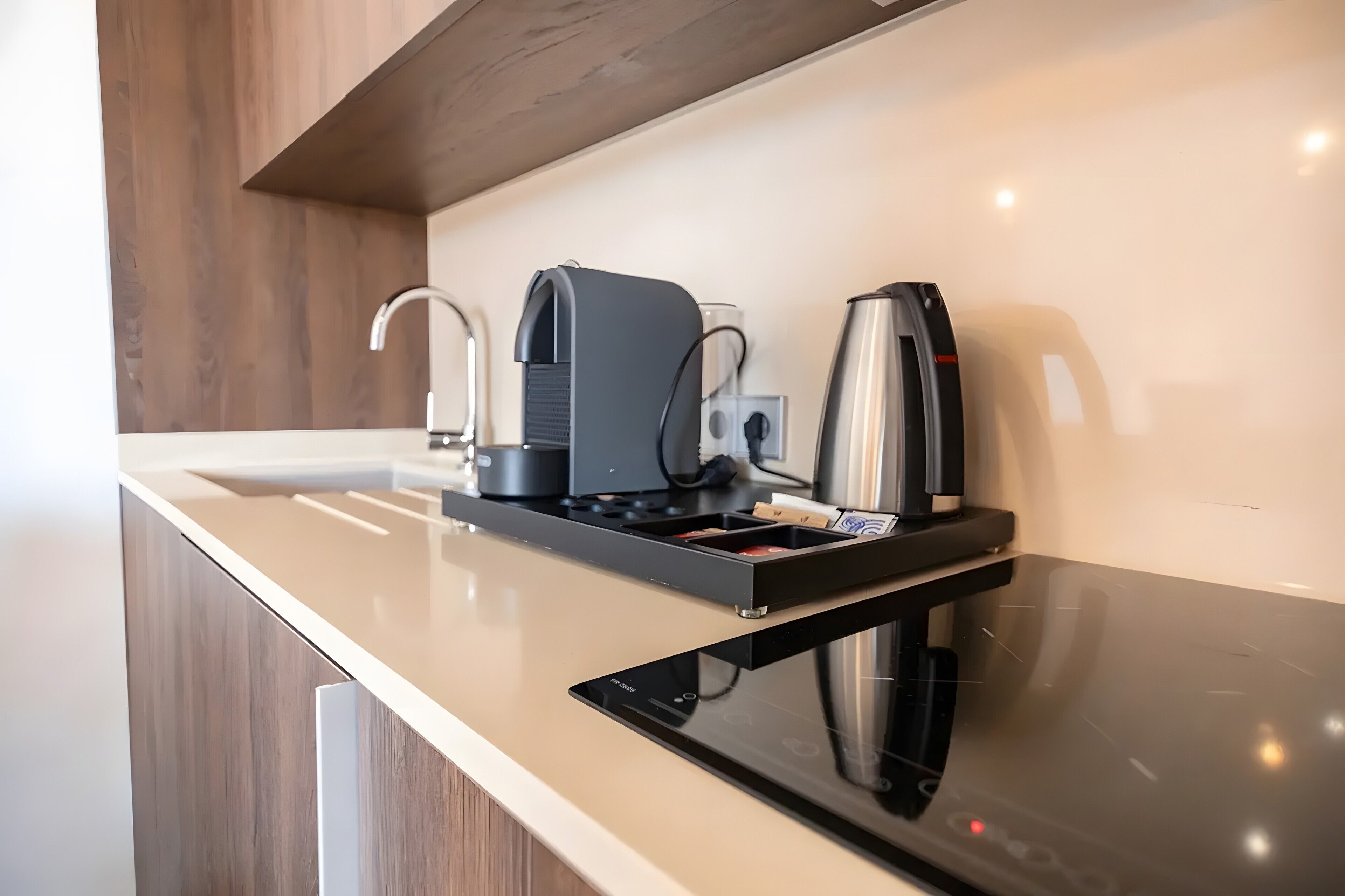Une cuisine moderne équipée d’une cuisinière intégrée, d’une machine à café et d’une bouilloire.