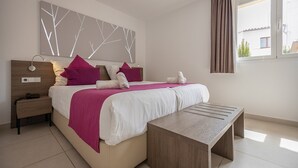 Ein modernes Schlafzimmer mit Bett, Nachttisch, Lampe und Blick ins Freie.