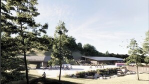 Un parc avec un bâtiment, des arbres et des personnes.